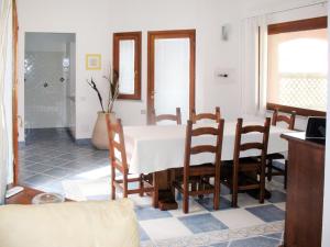 una sala da pranzo con tavolo e sedie bianchi di Holiday Home Rei Sole - REI302 by Interhome a Costa Rei