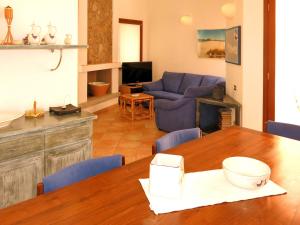 un soggiorno con tavolo e divano blu di Holiday Home Rei Sole - REI302 by Interhome a Costa Rei