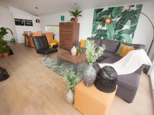 ein Wohnzimmer mit einem Sofa und einem Tisch in der Unterkunft Holiday Home Green Resort Mooi Bemelen by Interhome in Bemelen