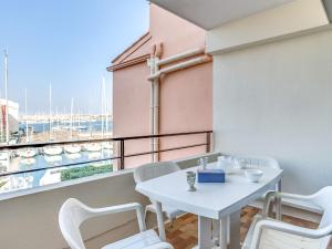 a white table and chairs on a balcony with a view at Apartment Les Ambassades du Soleil by Interhome in Cap d'Agde