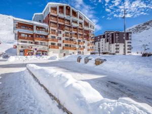 a snow covered street in front of a building at Studio Le Hameau du Borsat-11 by Interhome in Tignes