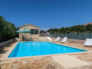 a swimming pool with chairs and a house at Holiday Home Camp Marko - ROZ335 by Interhome in Zečevo