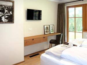 a bedroom with a bed and a desk with a tv at Apartment Chalet Edelweiß by Interhome in Auffach +49 photos