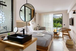 een slaapkamer met een bed, een spiegel en een wastafel bij Bali Star Resort Hotel in Balíon