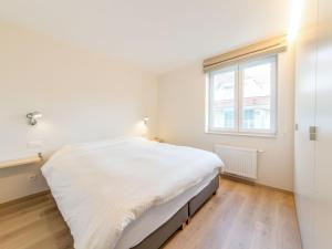 a white bedroom with a bed and a window at Apartment Wanderlust by Interhome in Mispelburg