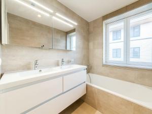 bagno con lavandino, vasca e finestra di Apartment Wanderlust by Interhome a Mispelburg