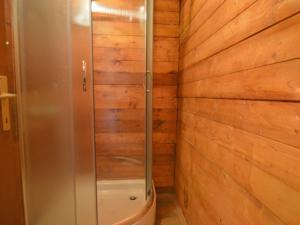 La salle de bains est pourvue d'une douche et d'un mur en bois. dans l'établissement Holiday Home Palma-5 by Interhome, à Anić