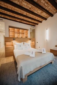 a large bedroom with a large bed with two signs on it at Petit Luxe St. Pere in Terrassa