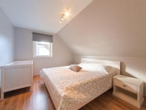 ein Schlafzimmer mit einem großen Bett im Dachgeschoss in der Unterkunft Holiday Home Boonenhove-3 by Interhome in De Haan