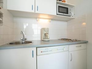 a kitchen with a sink and a microwave at Apartment Le Sunset-Cap Sud-20 by Interhome in Cap d'Agde