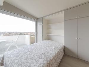a bedroom with a bed and a large window at Studio High in the sky with amazing views by Interhome in De Haan +12 photos