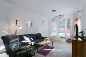 a living room with a black leather couch and a table at Apartment Anita in Dubrovnik