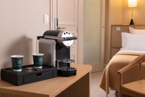 een hotelkamer met een koffiezetapparaat en twee kopjes op een tafel bij Hôtel Joe M in Parijs