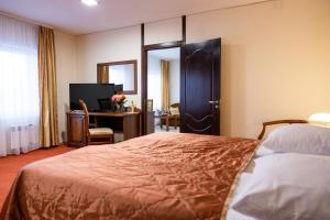 a bedroom with a bed and a desk and a mirror at 40th Meridian Arbat Hotel in Kolomna