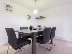 a dining room table with chairs and a white wall at Apartment Oliveres by Interhome in Torredembarra +25 photos