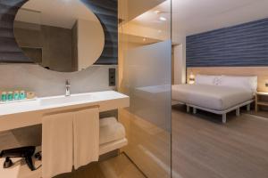 bagno con letto, lavandino e specchio di Hotel Spa Meiga do Mar a Caldebarcos