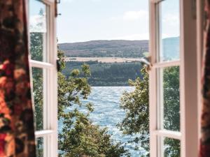an open window with a view of a lake at Holiday Home Burn Side by Interhome in Brackla