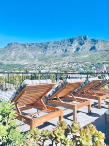 eine Reihe von Holzbänken auf einem Dach in der Unterkunft Cloud 9 Boutique Hotel and Spa in Kapstadt