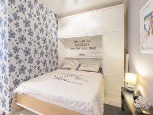 a bedroom with a bed with a flowery wallpaper at Studio Bowie with shared pool by Interhome in De Haan