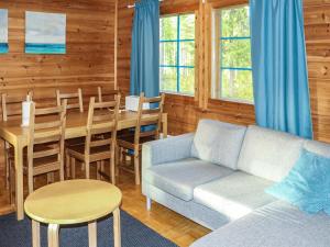 ein Wohnzimmer mit einem Sofa und einem Tisch in der Unterkunft Holiday Home Villa tassu 1 by Interhome in Kotila