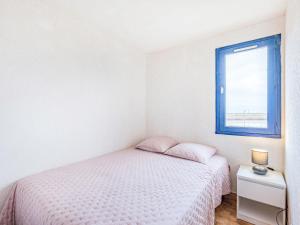 um quarto branco com uma cama e uma janela em Apartment Les terrasses de la Plage-4 by Interhome em Cap d'Agde