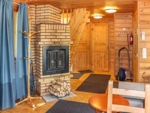 ein Wohnzimmer mit Kamin in einer Blockhütte in der Unterkunft Holiday Home Villa tassu 2 by Interhome in Kotila