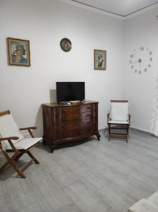 sala de estar con TV y 2 sillas en Plebiscito Street, en Nápoles