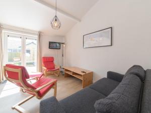 a living room with a couch and a table at Holiday Home Duinenhuisje 25 parking and shared pool by Interhome in De Haan