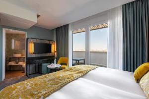 una camera d'albergo con un grande letto e una TV di voco Paris Montparnasse, an IHG Hotel a Parigi