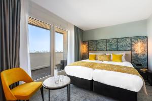 voco Paris Montparnasse, an IHG Hotel في باريس: غرفة فندقية بسرير كبير ونافذة