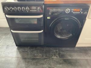 a stove and a washing machine in a kitchen at Commuters Getaway in Chesterfield