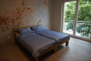 a bed in a bedroom with a large window at 2nd Home Appartements 23 in Nieder-Olm