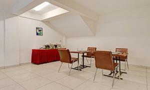 Treebo Trend Fortune Stay في بانغالور: غرفة طعام مع كراسي وطاولة مع قطعة قماش من الطاولة الحمراء