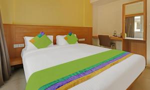 Treebo Trend Fortune Stay في بانغالور: غرفة نوم مع سرير أبيض كبير مع بطانية ملونة