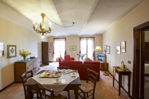 salon ze stołem i czerwonymi krzesłami w obiekcie Relais Castello di Razzano w mieście Alfiano Natta