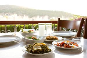 a table with several plates of food on it at Yalcin Hotel in Çeşme
