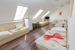 um dormitório com 3 camas e uma secretária em Penzion Hviezda em Bratislava