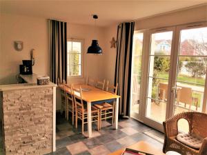 eine Küche und ein Esszimmer mit einem Tisch und Stühlen in der Unterkunft LE BOCAGE 38 - Bourgenay - Piscine chauffee in Saint-Hilaire-de-Talmont
