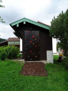a building with a climbing wall in a yard at Ferienwohnung Jagdhäusl in Bernau am Chiemsee