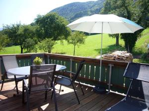 una mesa y sillas en una terraza con sombrilla en Ferienwohnung Jagdhäusl en Bernau am Chiemsee