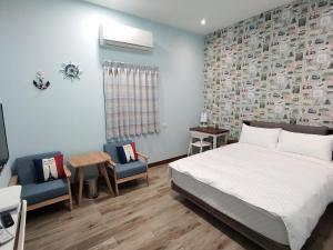 Un dormitorio con una cama y dos sillas. en LaiKe B&B, en Xiaoliuqiu