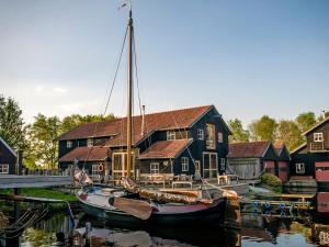 a boat is docked in front of a house at Holiday Home Bungalowpark It Wiid in Eernewoude