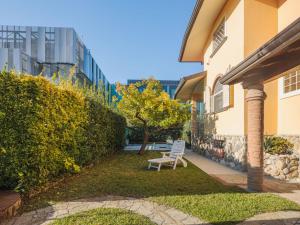 a chair sitting in the grass next to a building at Apartment Lara by Interhome in Marina di Massa