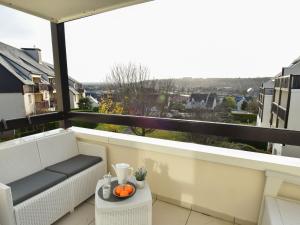einen Balkon mit einer Bank und einem Tisch mit Orangen darauf in der Unterkunft Apartment Le Vert Coteau-3 by Interhome in Touques