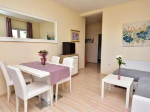 salon ze stołem, krzesłami i kanapą w obiekcie Apartment Melandura-1 by Interhome w mieście Dinjiška