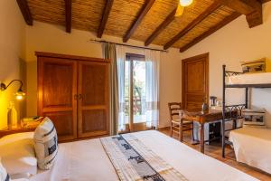 1 dormitorio con 2 camas, escritorio y ventana en Agriturismo Canales, en Dorgali