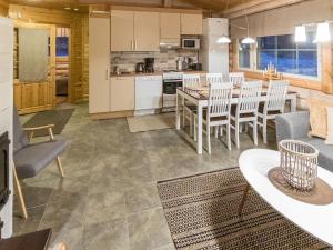 Il comprend une cuisine et un salon avec une table et des chaises. dans l'établissement Holiday Home Villa lempi by Interhome, à Äkäslompolo