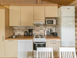 Il comprend une cuisine équipée d'appareils électroménagers blancs et d'un réfrigérateur blanc. dans l'établissement Holiday Home Villa lempi by Interhome, à Äkäslompolo