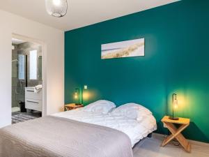 a bedroom with a white bed and a green wall at Holiday Home Villa LANKA by Interhome in Arzon