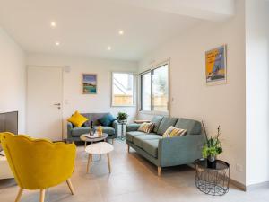 a living room with two couches and a table at Holiday Home Villa Lanka by Interhome in Arzon